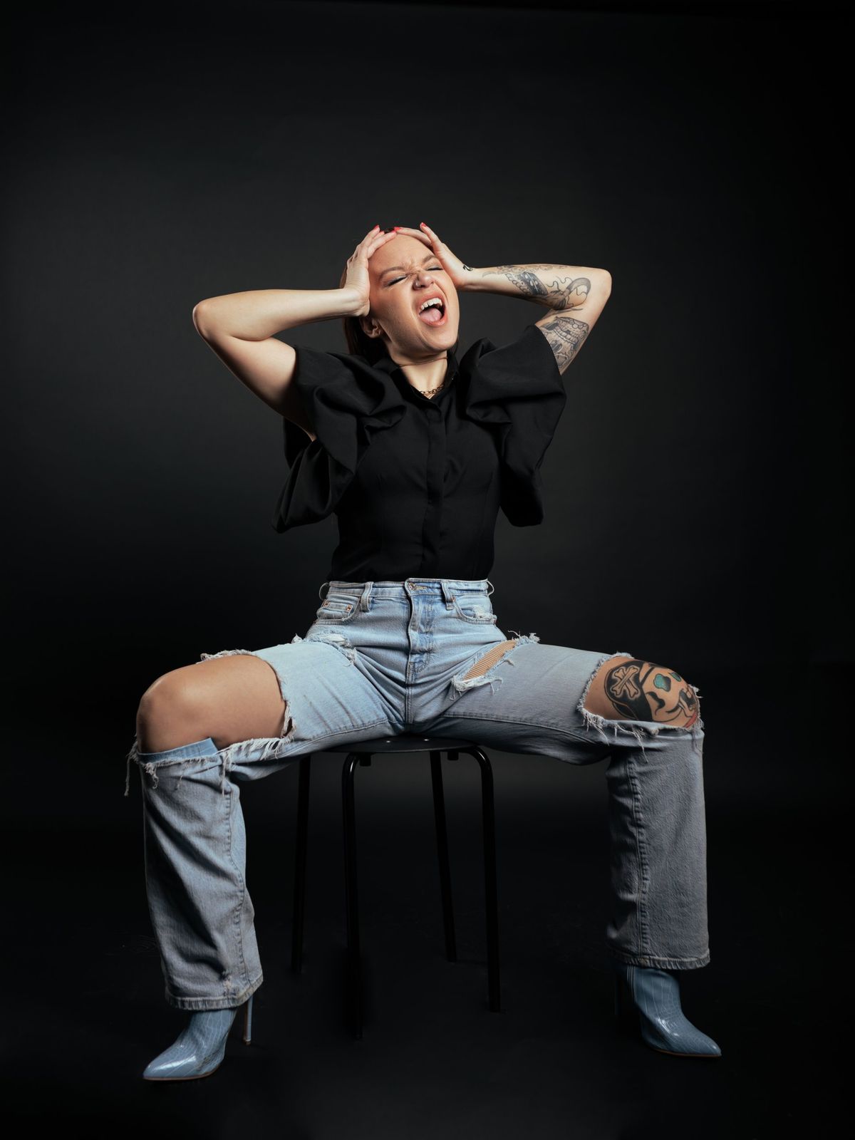 Editorial portrait seated in distressed denim
