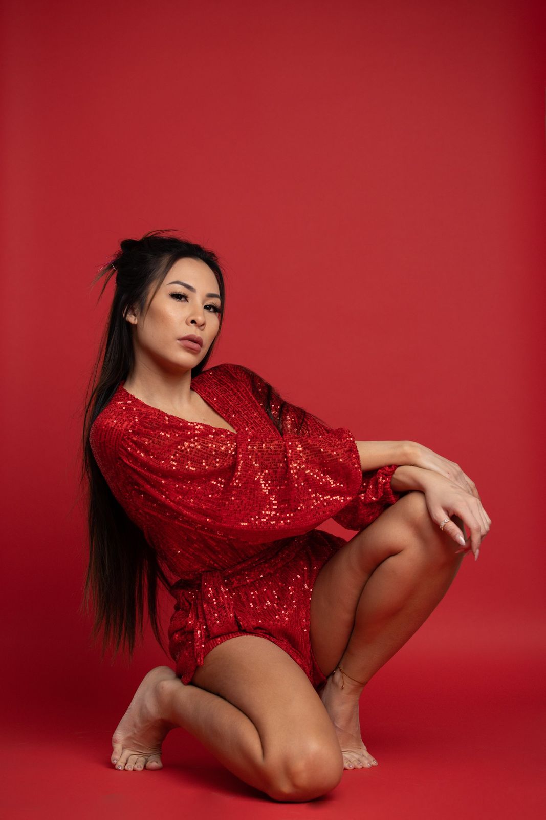 Editorial portrait in a red sequin dress on a red backdrop