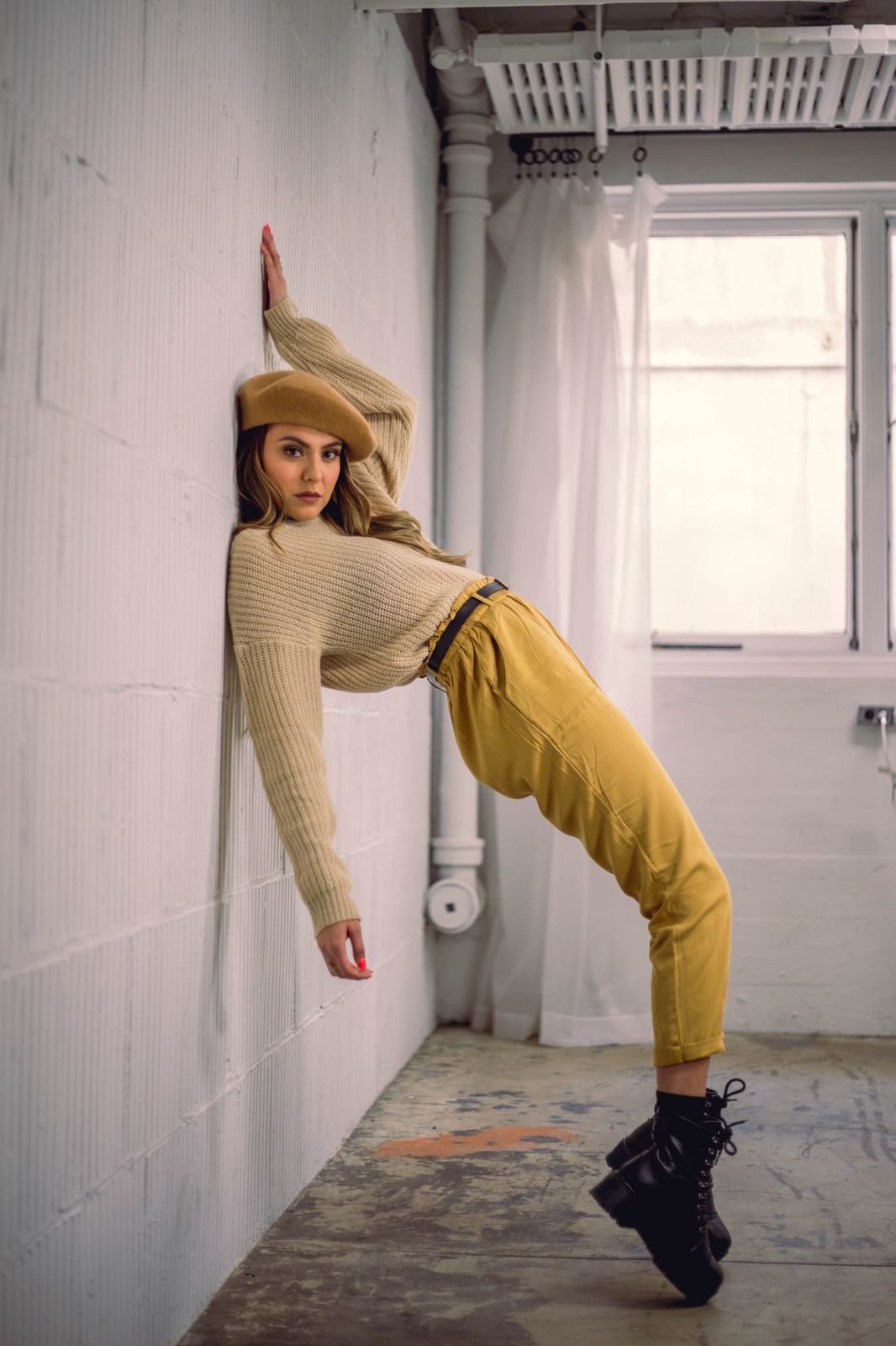 Lifestyle portrait leaning against a studio wall