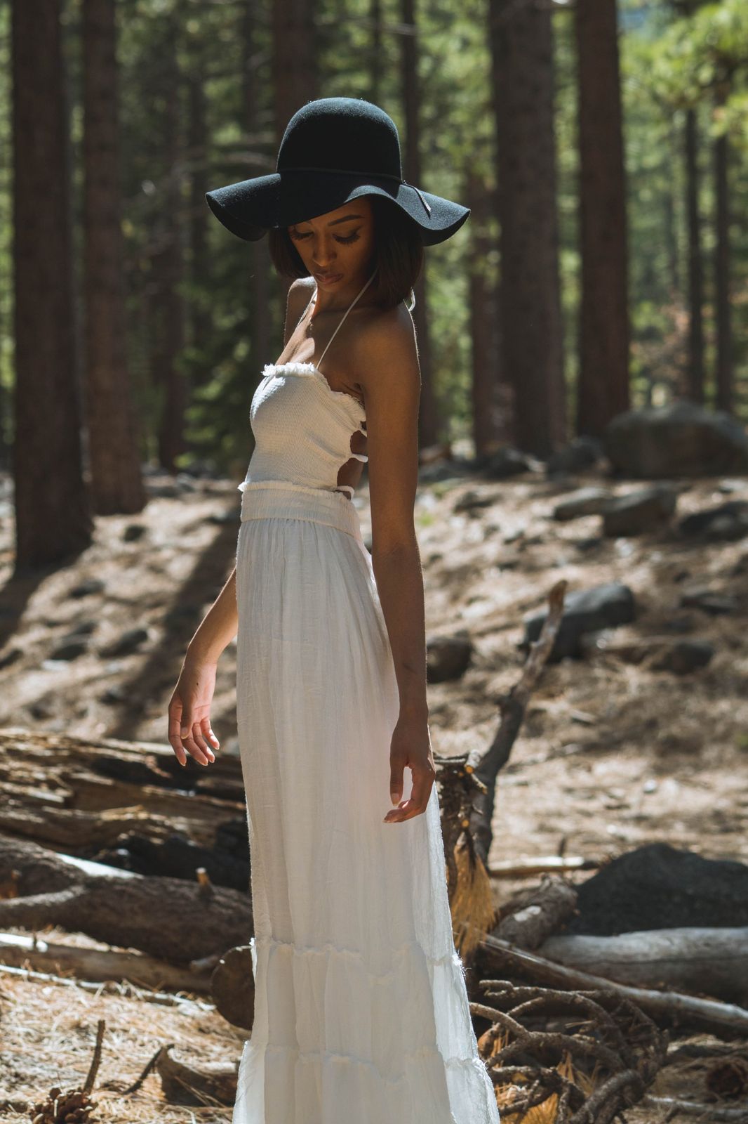 Lifestyle portrait in a wide-brim hat among the pines