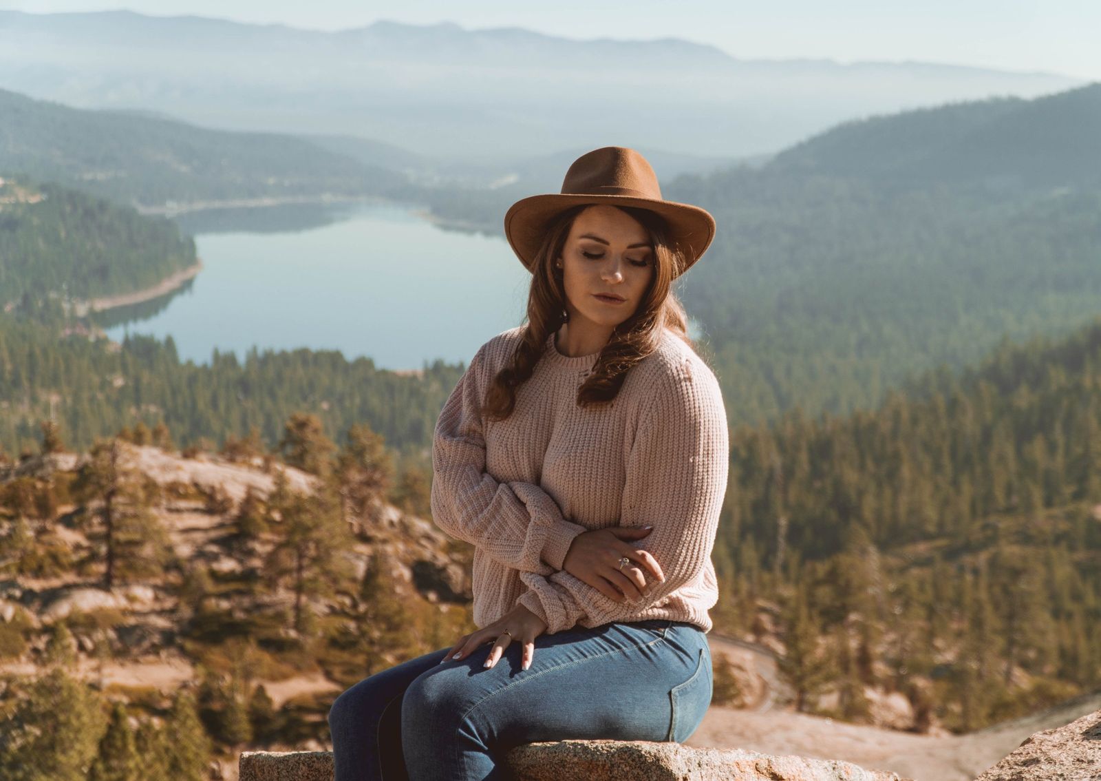 Lifestyle portrait seated above Donner Lake in a felt hat