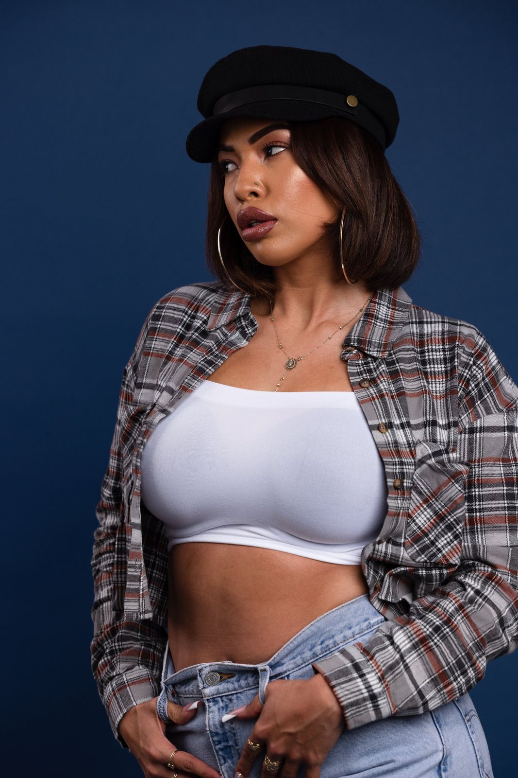 Portrait in a cap and plaid shirt on a blue backdrop