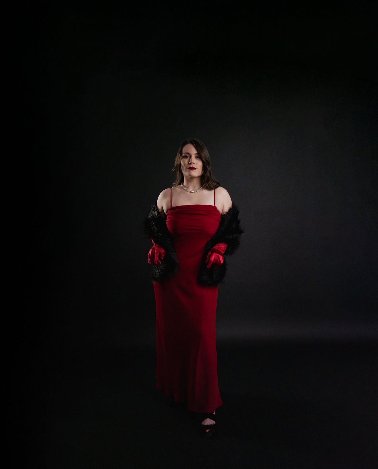 Editorial portrait in a red gown with a fur stole