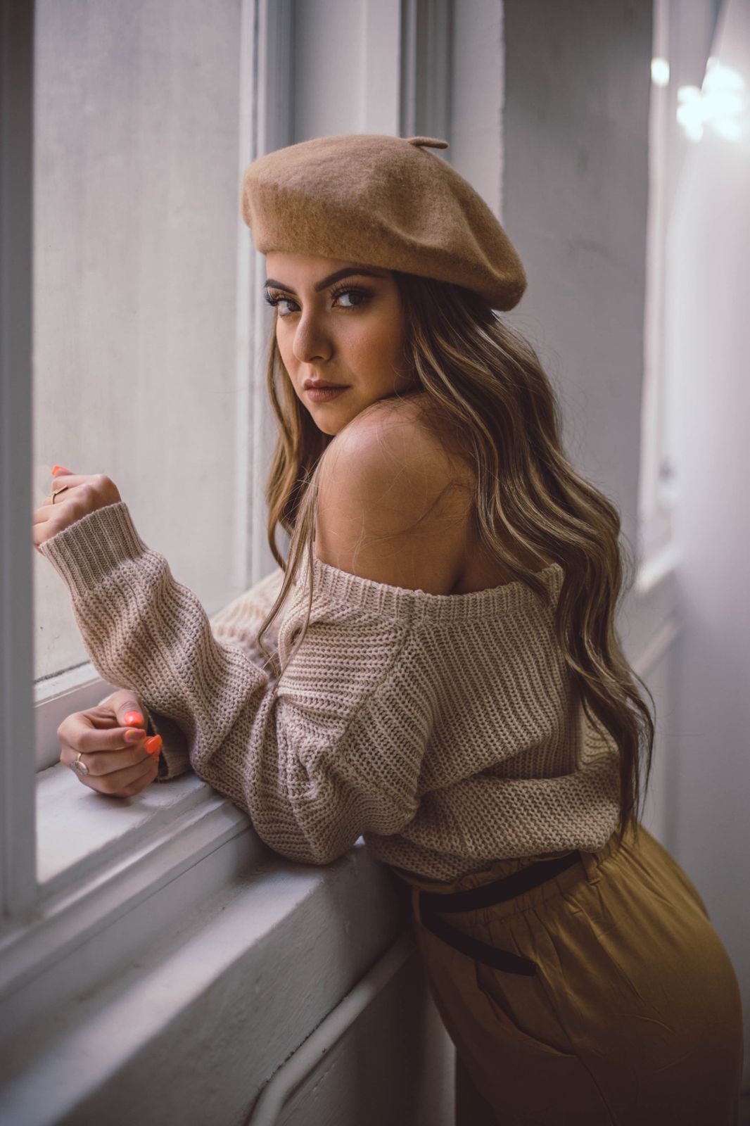 Portrait at a window in a beret and knit sweater